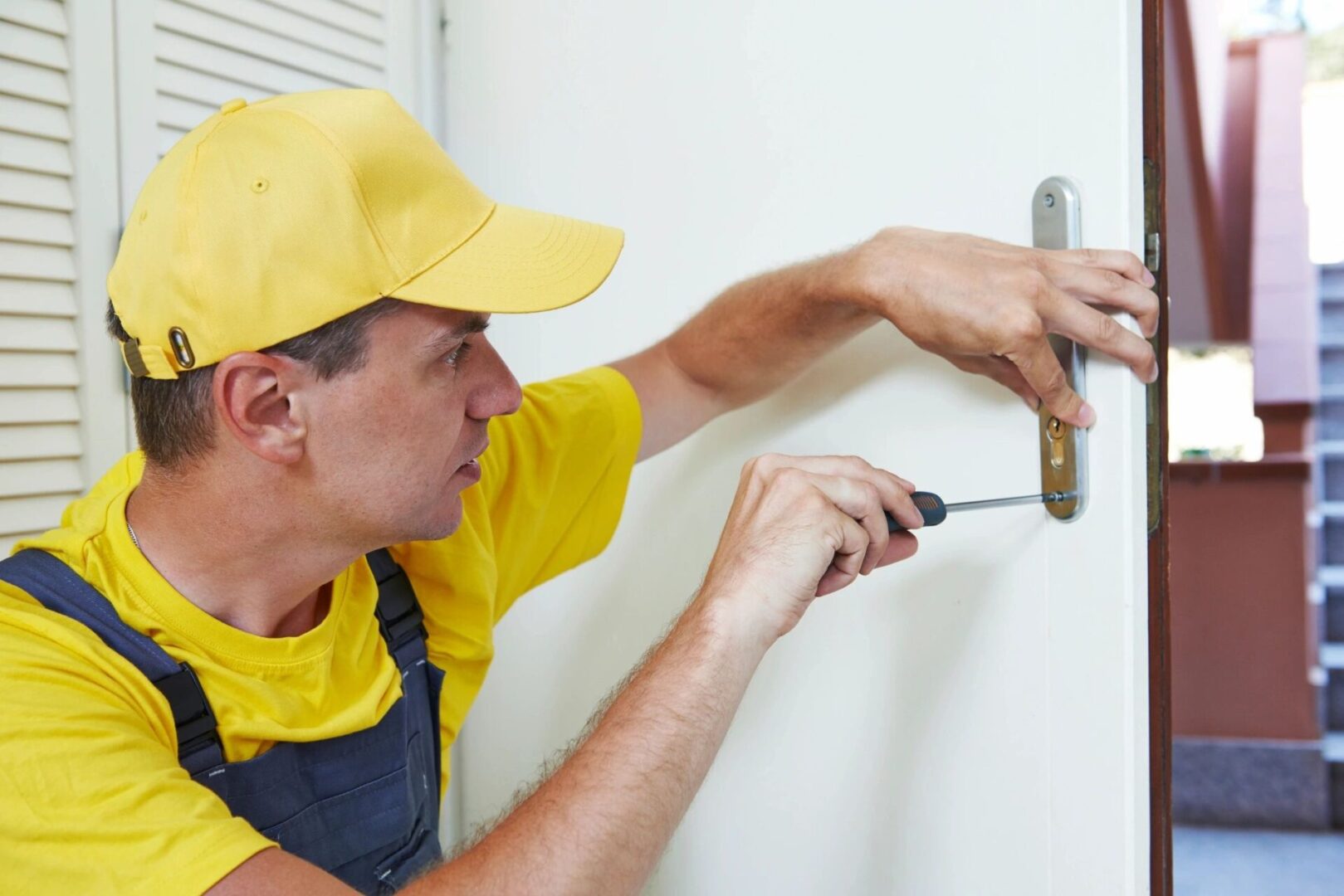 A man in yellow shirt holding a screwdriver.