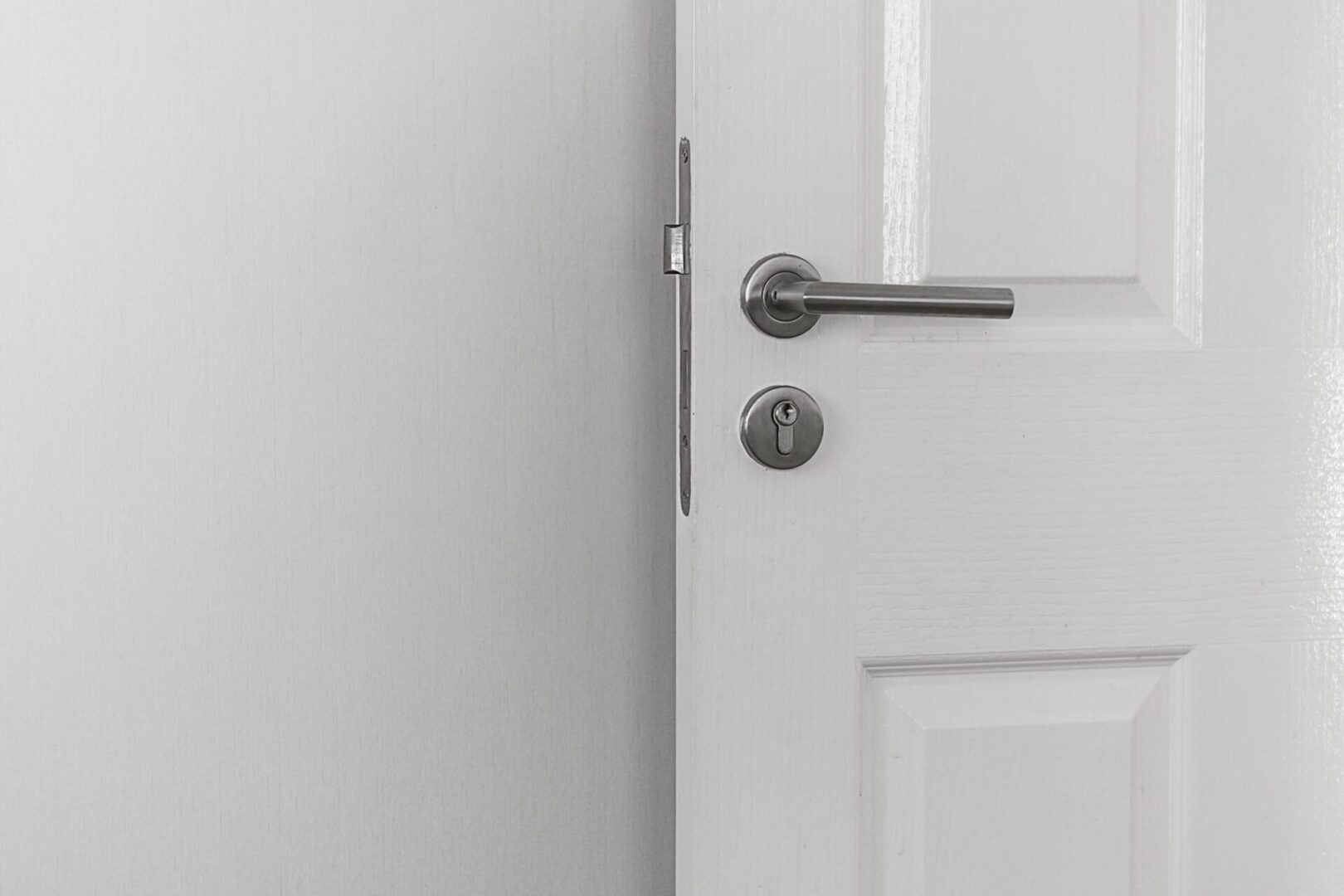 A door handle and lock on the inside of a white door.