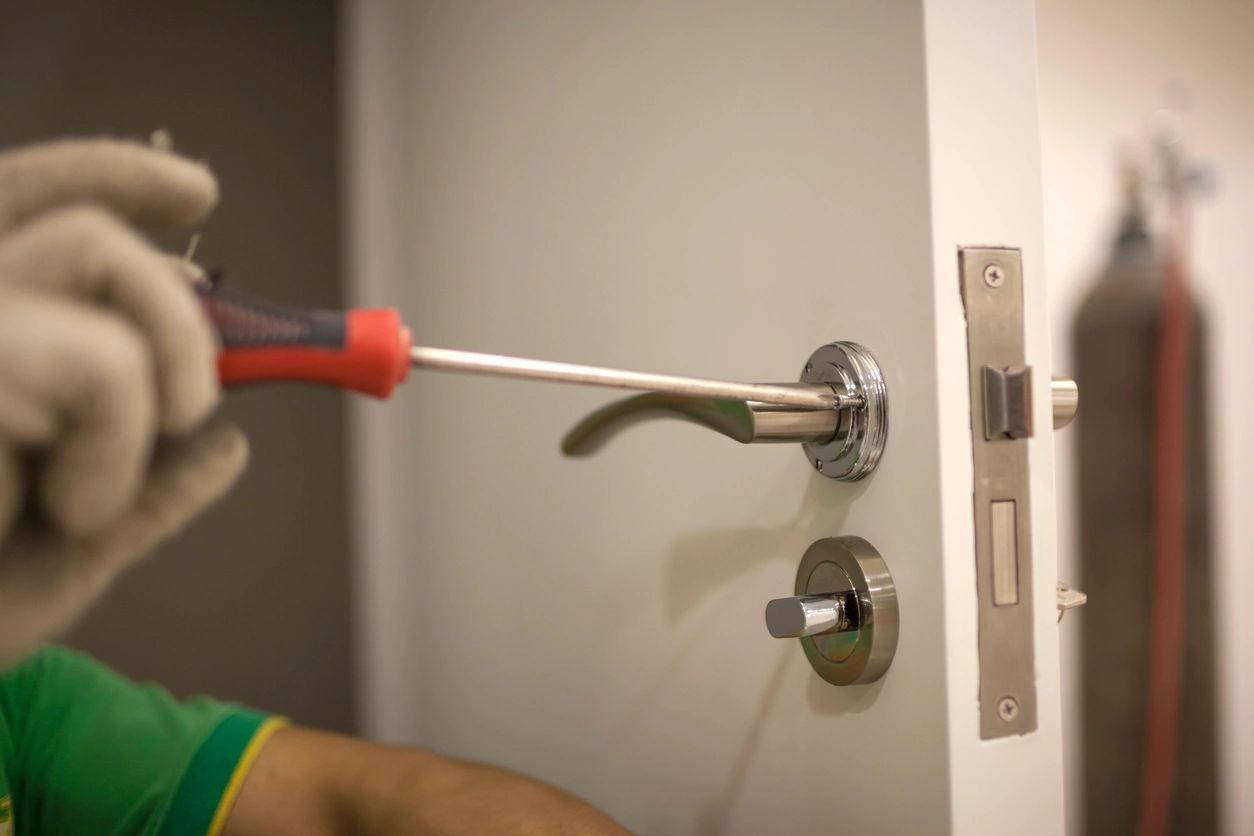 A person using a screwdriver to open the door.