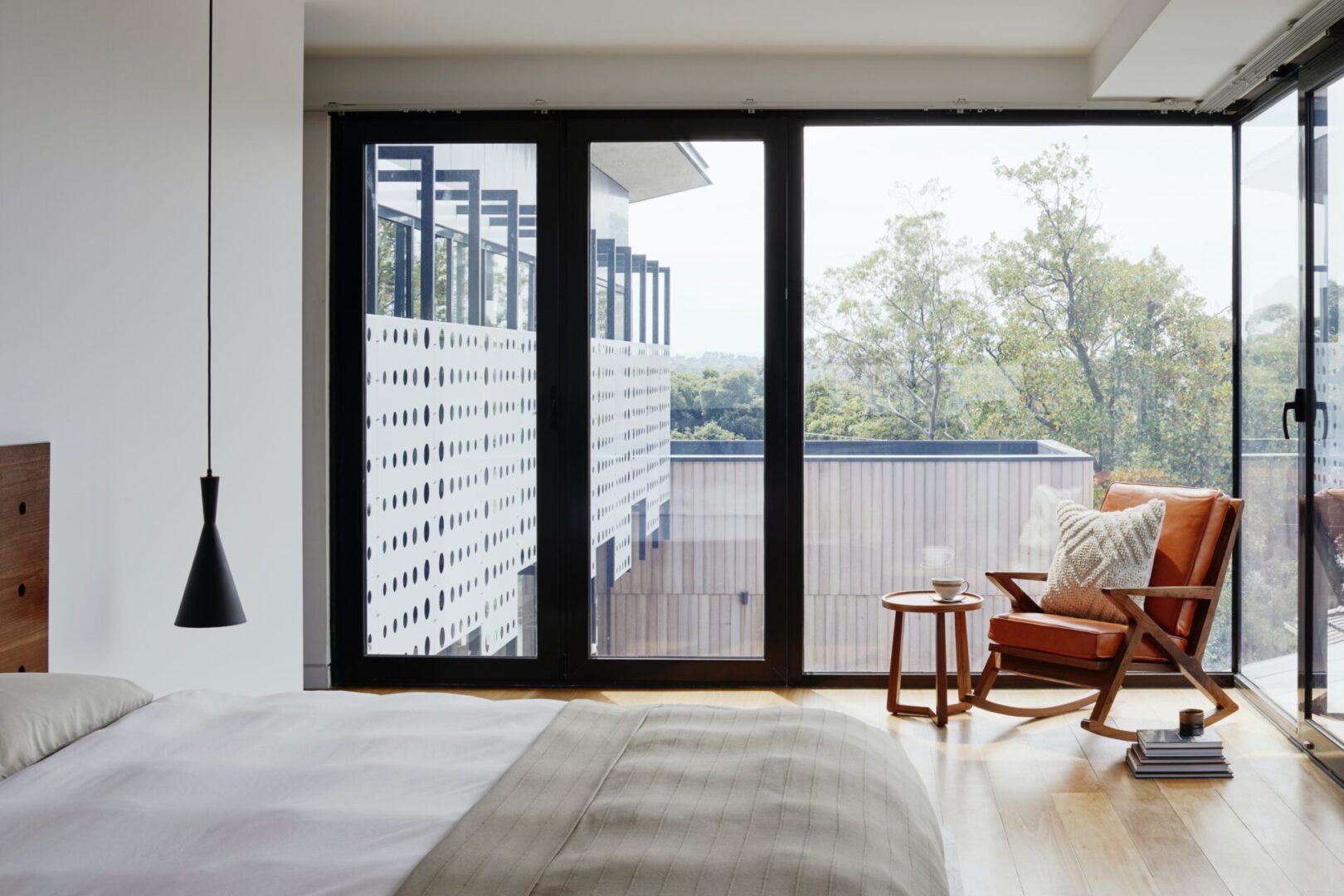 A bedroom with a large window and a chair